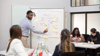 students interact with professor in classroom